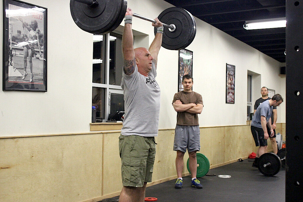 Tim shoulder pressing during the 1700 WOD class.