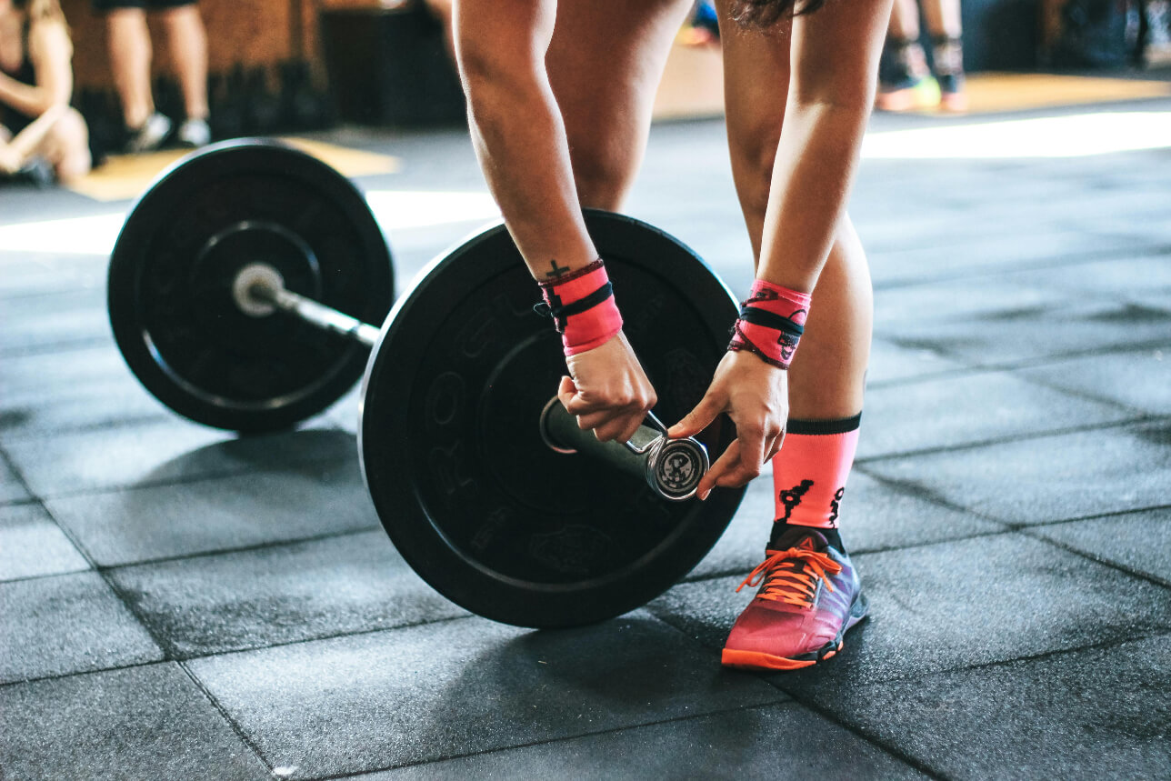Female deadlift changing plates pink shoes